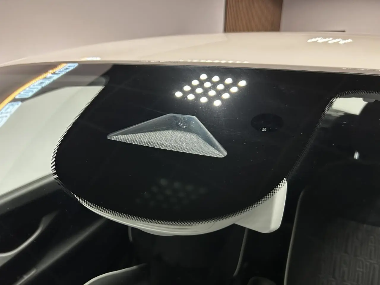 Détail du capteur d'alerte de franchissement de ligne visible derrière le pare-brise d'une Fiat 500 blanche électrique.