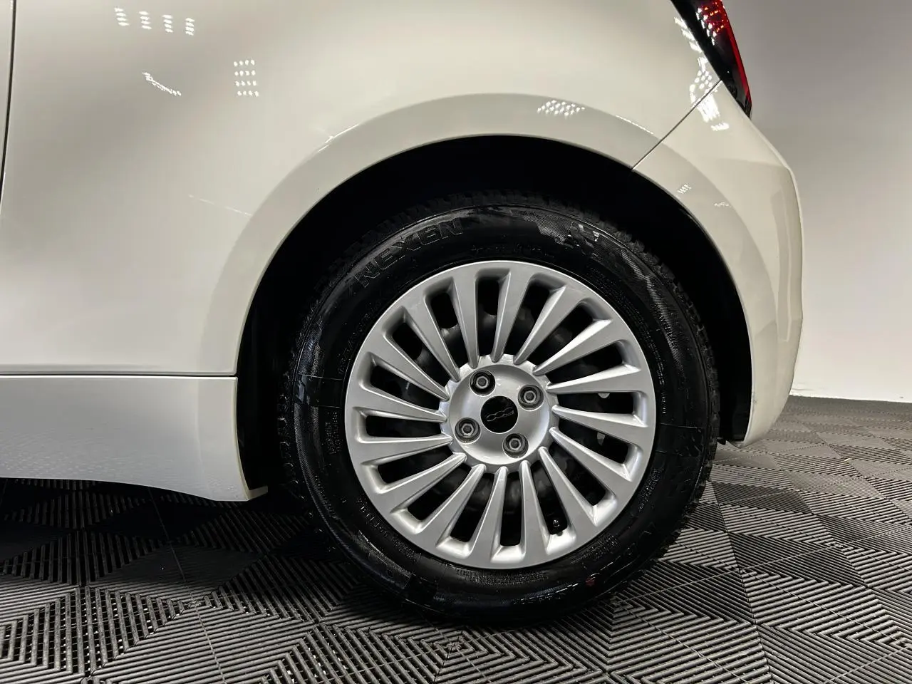 Gros plan sur la roue arrière droite blanche d'une FIAT 500 électrique 2024 avec jante acier 15 pouces.