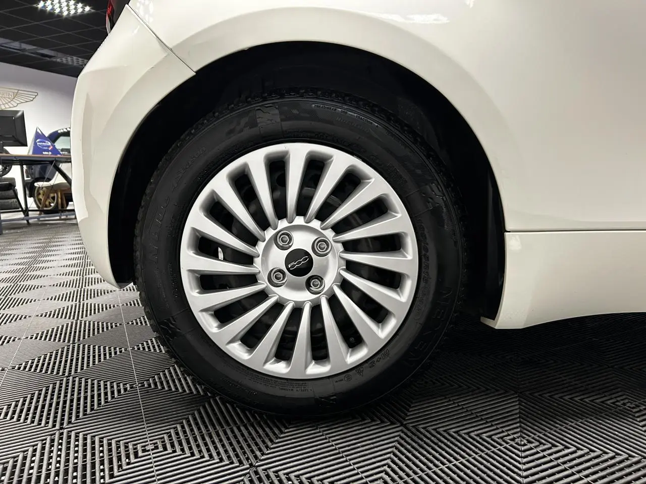 Gros plan sur la roue arrière droite blanche d'une FIAT 500 électrique 2024 avec jante acier 15 pouces.