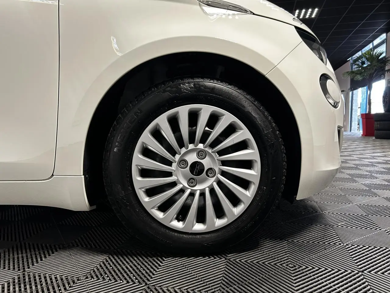 Gros plan sur la roue avant droite d'une FIAT 500 électrique blanche 2024 avec jante acier 15 pouces.