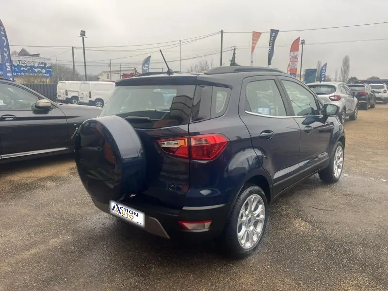 Ford EcoSport Bleu Abysse vu de 3/4 arrière droit, avec roue de secours extérieure et jantes alu brillantes.