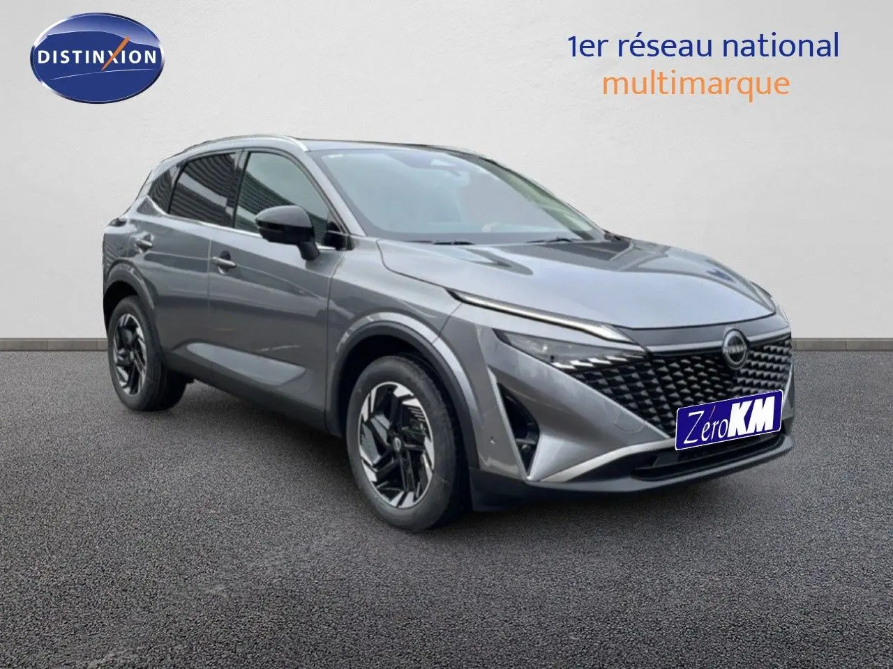 Nissan Qashqai 2025 gris squale métal en 3/4 avant, avec calandre noire distinctive et jantes bi-ton.