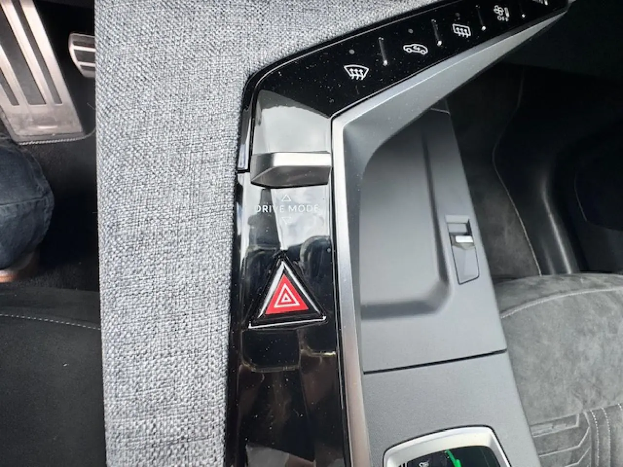Gros plan sur la console centrale noire et tissu gris avec bouton de mode de conduite et alerte de danger du Peugeot 3008 gris titane.