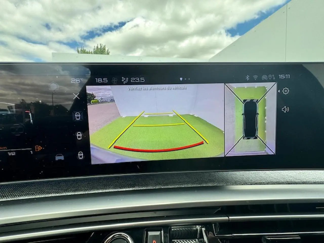 Vue de l'écran intérieur du Peugeot 3008 2024 montrant la caméra de recul et la vue à 360° du véhicule hybride gris titane.