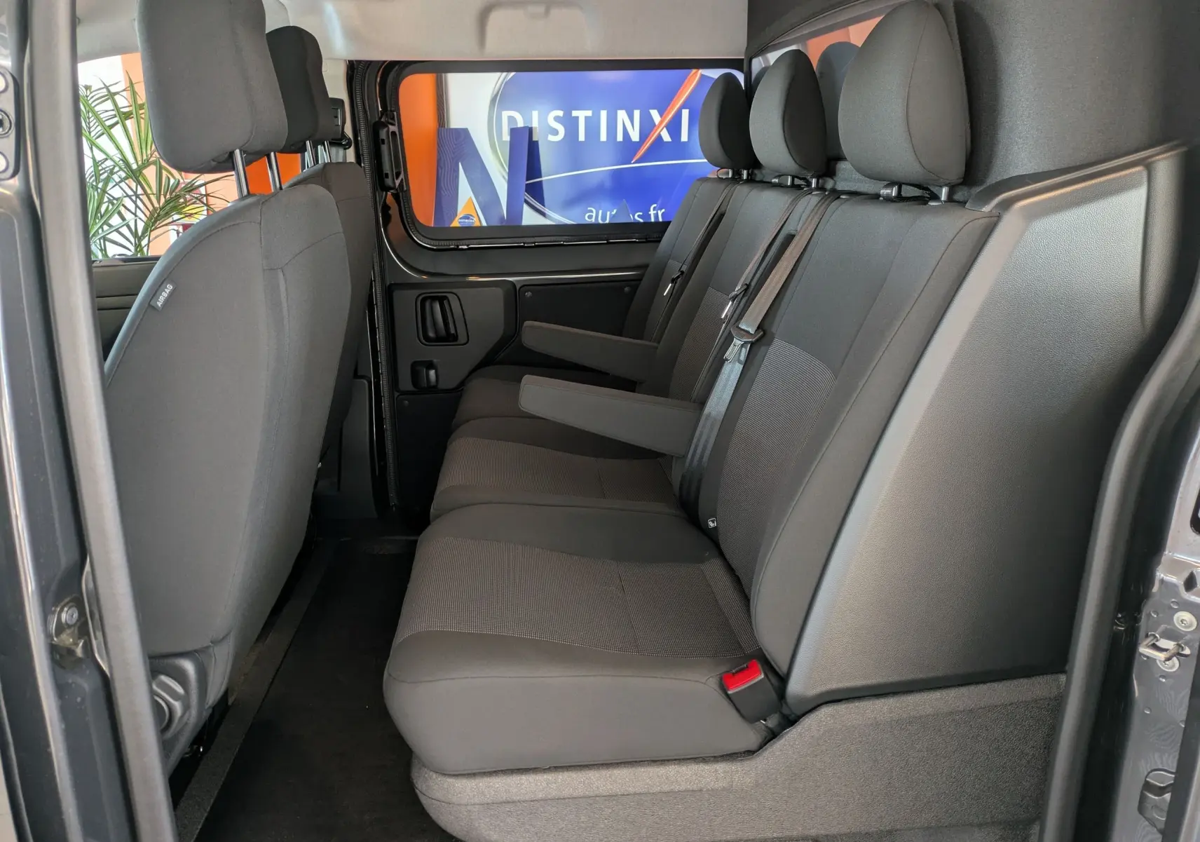 Vue intérieure côté droit du Citroën Jumpy gris titane, montrant la banquette arrière 3 places avec accoudoirs.
