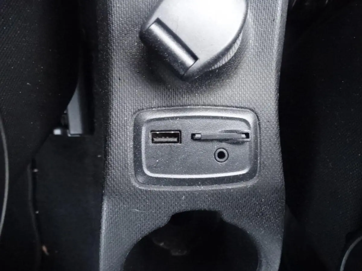 Gros plan sur les prises USB et auxiliaire intégrées dans la console centrale noire d'une Smart Forfour électrique blanche.