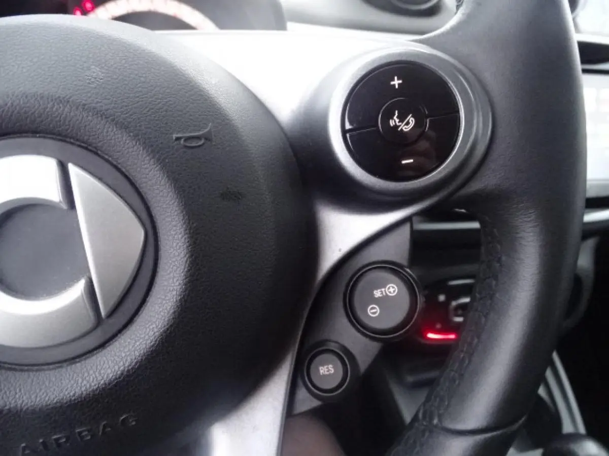 Gros plan sur le volant cuir multifonctions de la Smart Forfour Electric Drive Prime 2018 avec commandes de régulateur de vitesse.