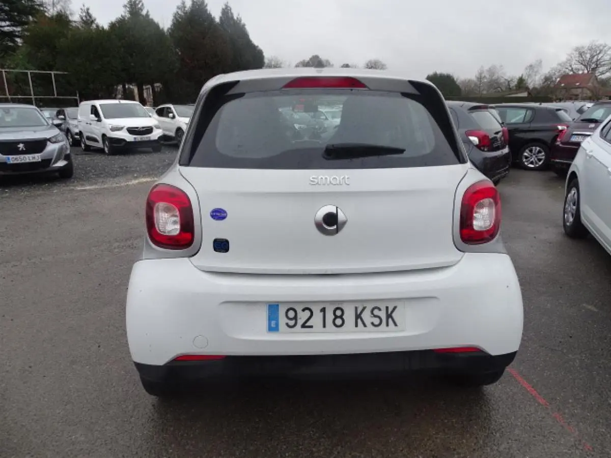 Vue arrière d'une Smart Forfour électrique blanche avec logo smart EQ et feux arrière rouges.