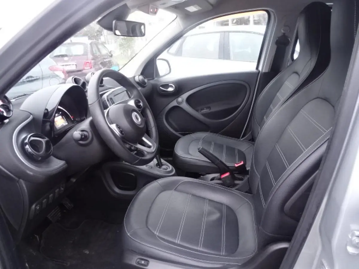 Vue intérieure côté conducteur de la Smart Forfour Electric Drive 2018, sellerie cuir noir et volant multifonctions.