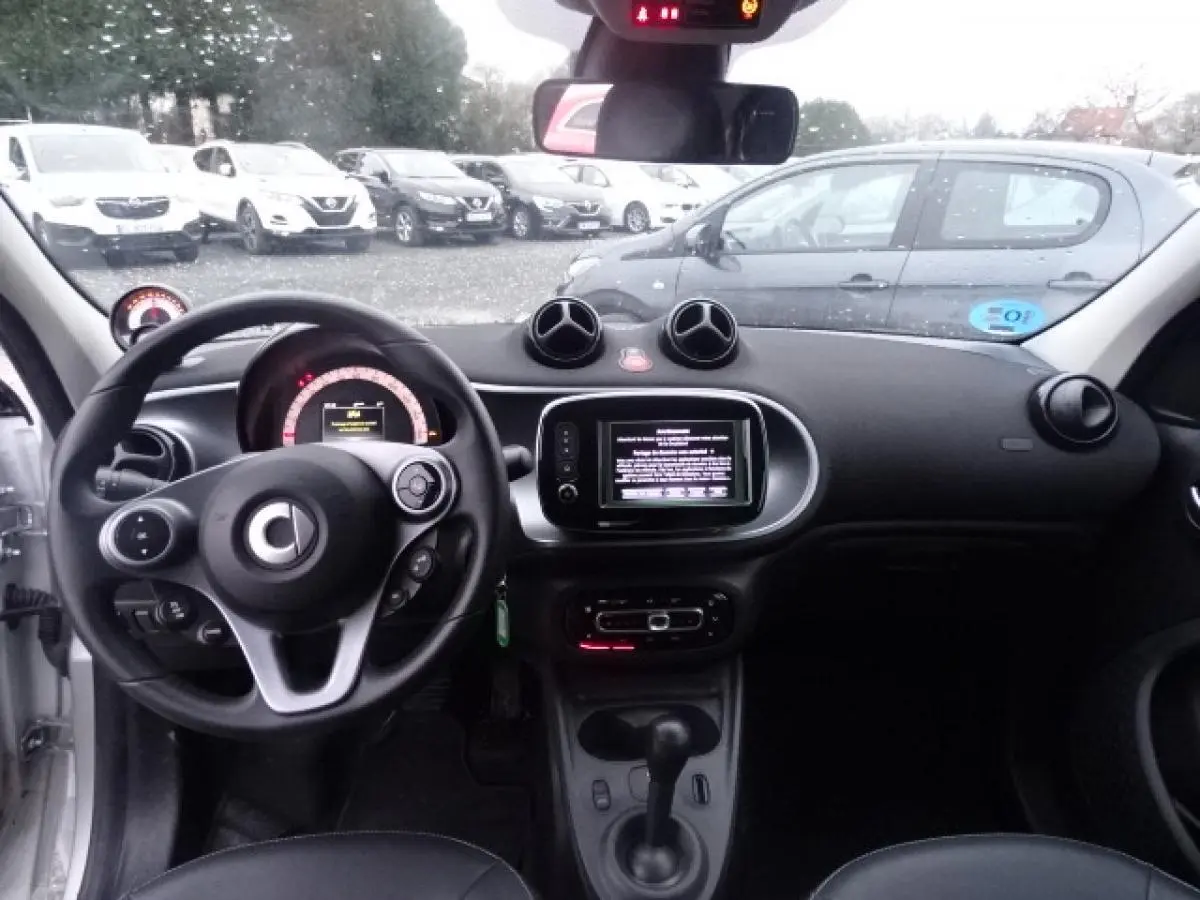 Vue intérieure avant du tableau de bord et volant cuir multifonctions de la Smart Forfour Electric Drive Prime blanche de 2018.