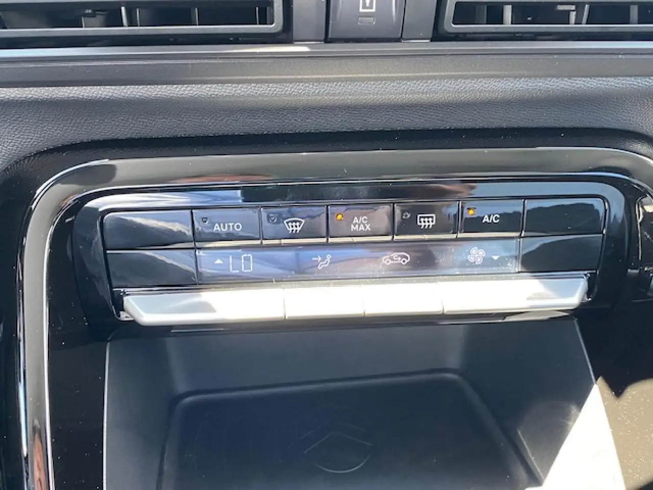 Gros plan sur la console centrale noire du Citroën C3 Aircross 2026, affichant les commandes de climatisation automatique.
