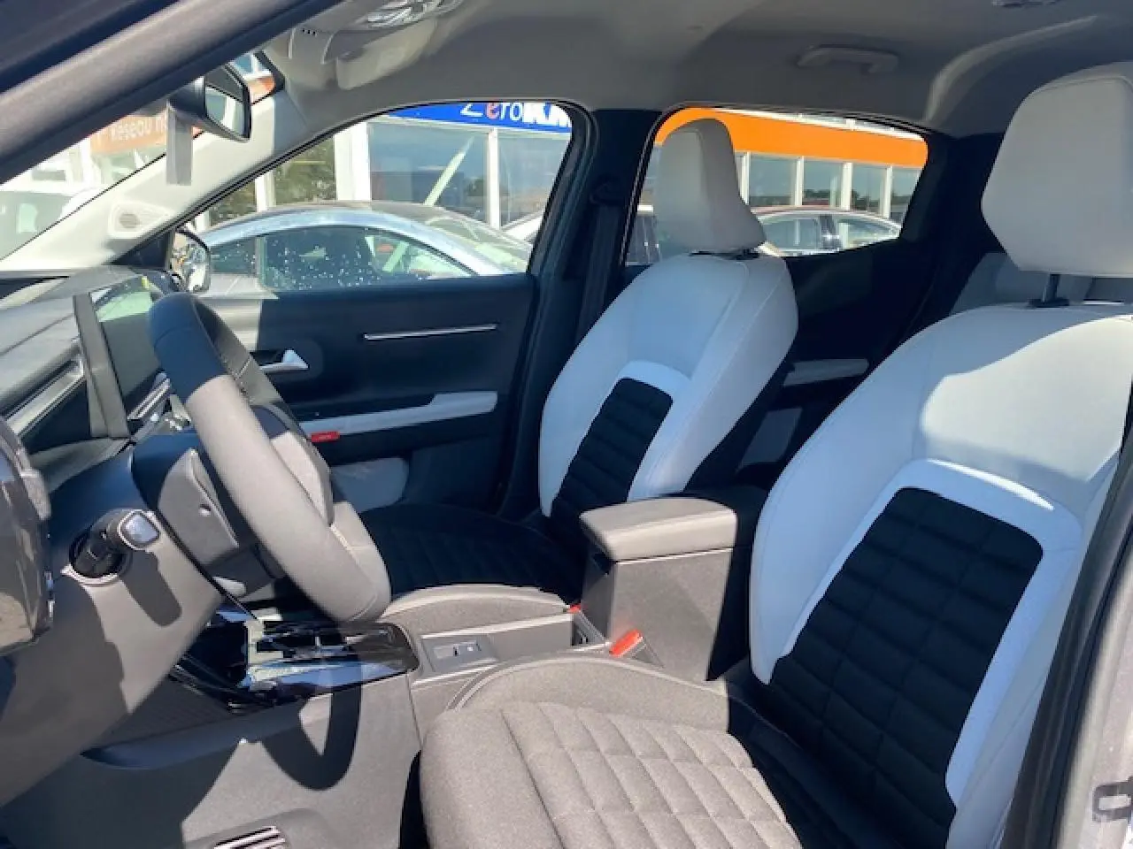 Vue intérieure avant du Citroën C3 Aircross 2026, sièges bicolores noir et blanc avec console centrale et volant multifonctions.
