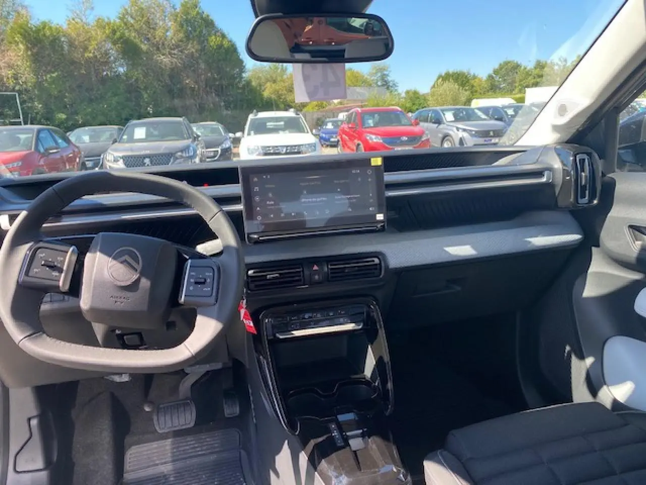 Vue intérieure avant du Citroën C3 Aircross 2026, tableau de bord gris clair avec écran tactile central et volant multifonctions.
