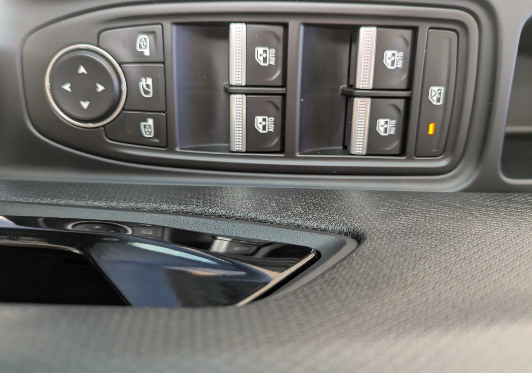 Gros plan sur les commandes des vitres électriques et rétroviseurs côté conducteur d'une Renault Clio VI TCe 115ch finition Techno.