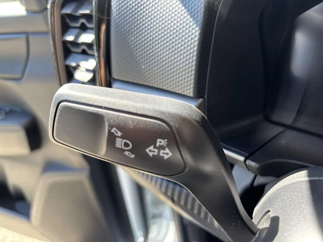 Gros plan sur la manette de clignotants noire à l'intérieur du Ford Ranger blanc glacier, côté gauche du volant.