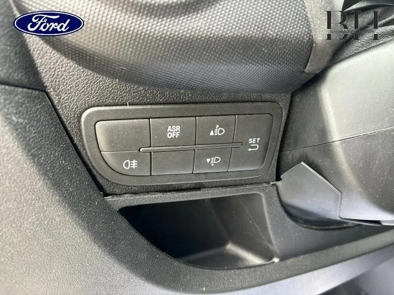 Panneau de commandes des feux et de l'ASR en gros plan, intérieur noir d'un Fiat Fiorino blanc 2018.