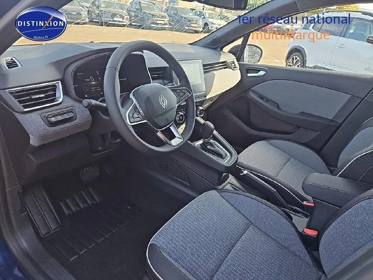 Intérieur avant de la Renault Clio V 1.6 e-tech bleu iron, vue côté conducteur avec volant multifonction et sièges sport.
