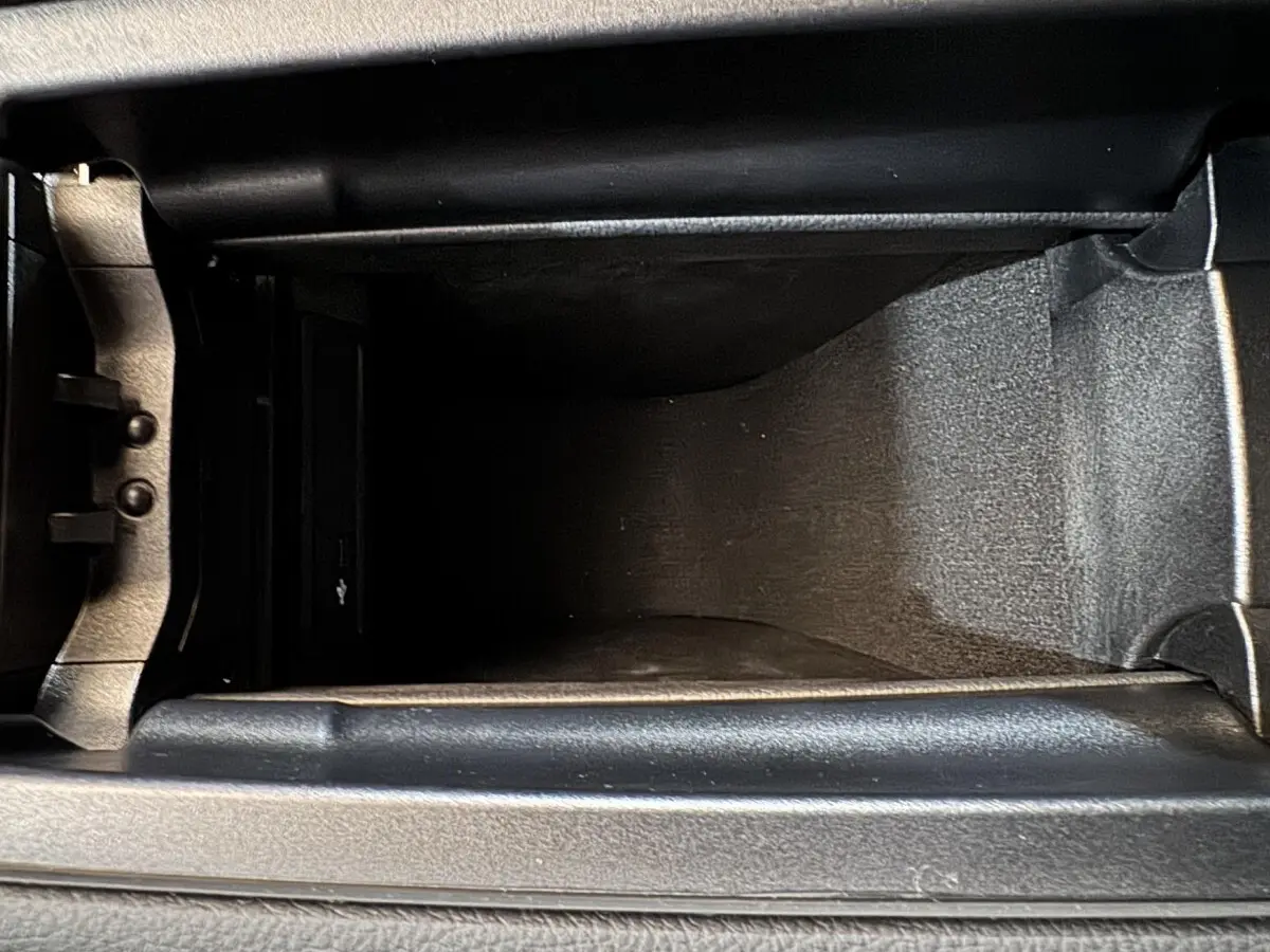 Vue plongeante sur le compartiment de rangement central intérieur du Mercedes GLA 250 e Business Line gris foncé 2023.