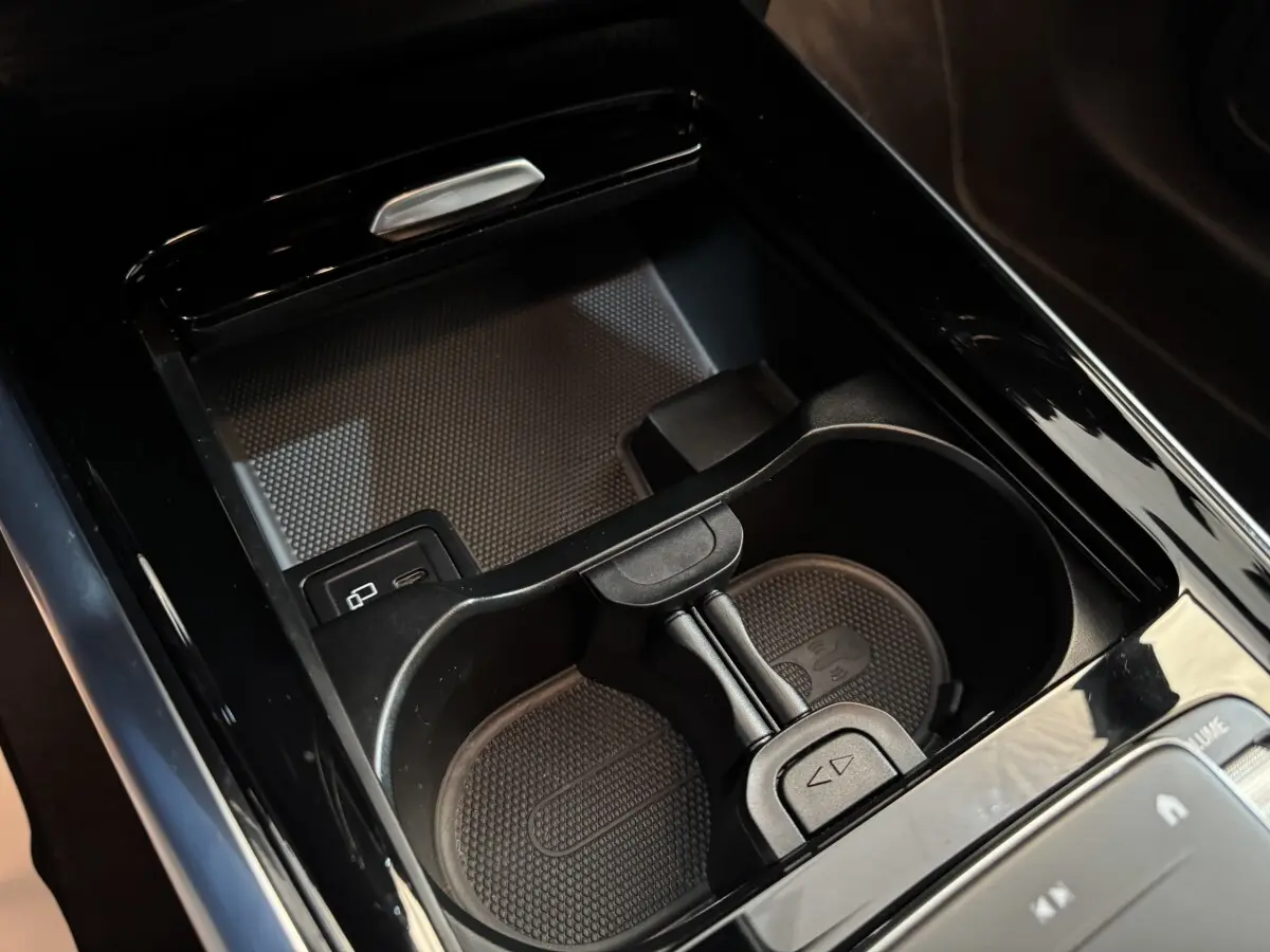 Gros plan sur le porte-gobelets noir brillant et la console centrale du Mercedes GLA 250 e Business Line 2023.