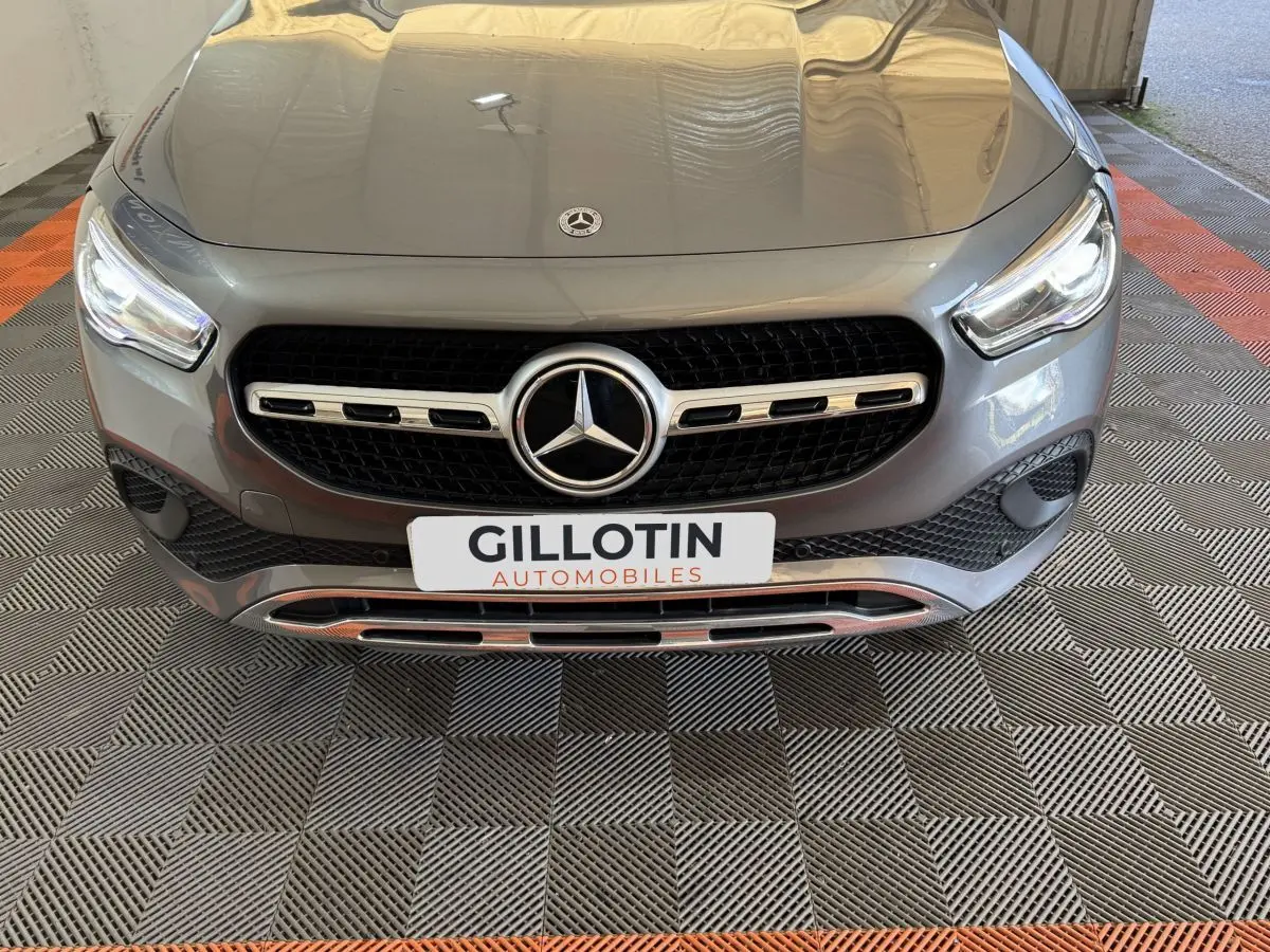 Vue avant rapprochée d’une Mercedes GLA 250 e Business Line gris foncé avec calandre étoile et plaque GILLOTIN.