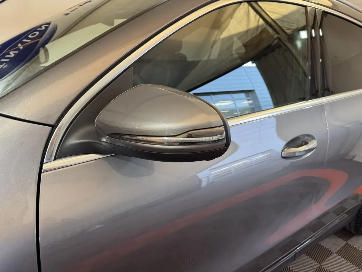 Gros plan sur le rétroviseur côté gauche gris foncé du Mercedes GLA 250 e Business Line 2023 avec porte et fenêtre visibles.