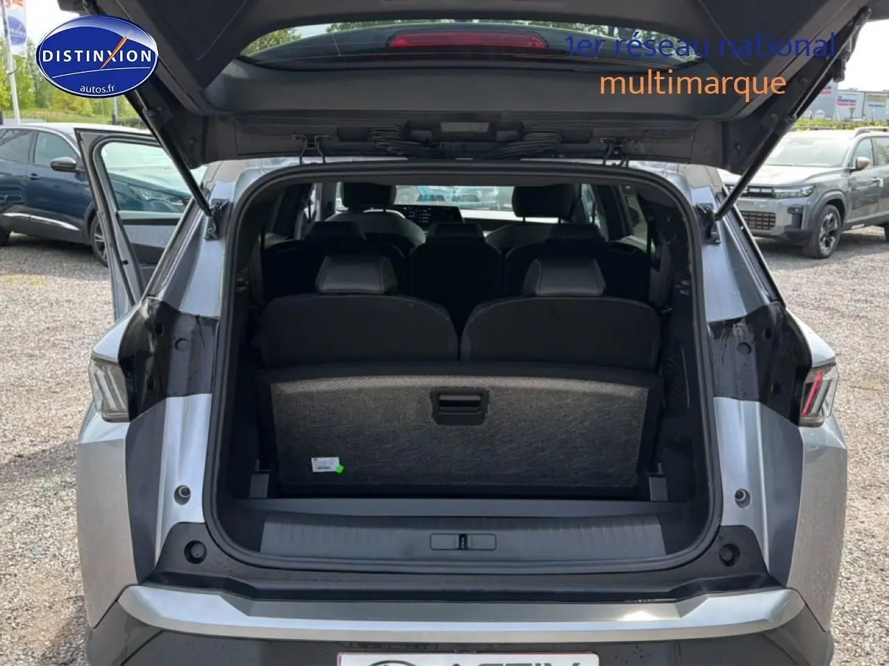 Vue arrière ouverte du Peugeot 5008 gris artense montrant les sièges rang 3 et le coffre spacieux.