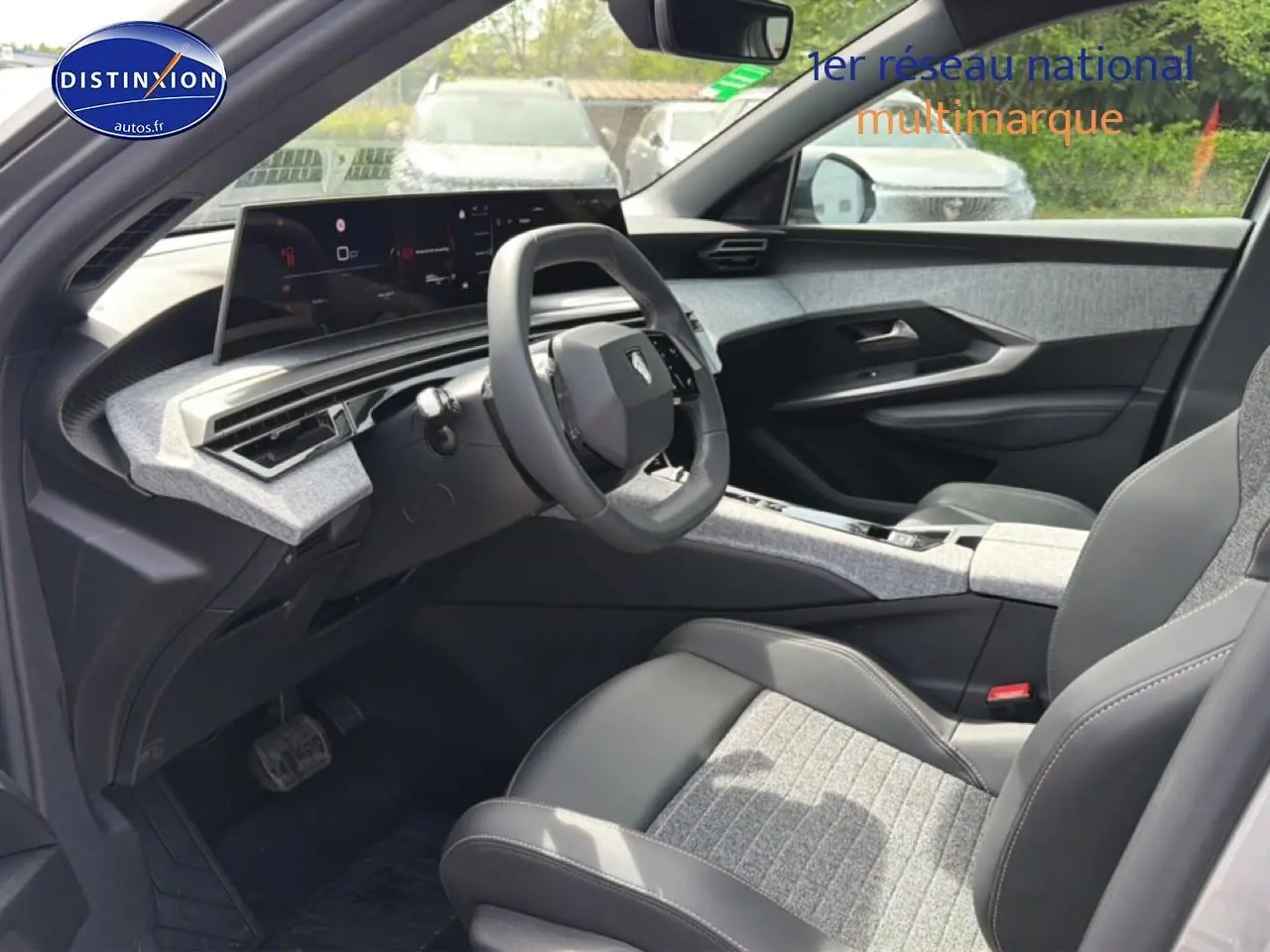 Vue intérieure côté conducteur du Peugeot 5008 Hybrid 145 allure e-dcs6 2025, avec sièges tissu gris et cuir noir.