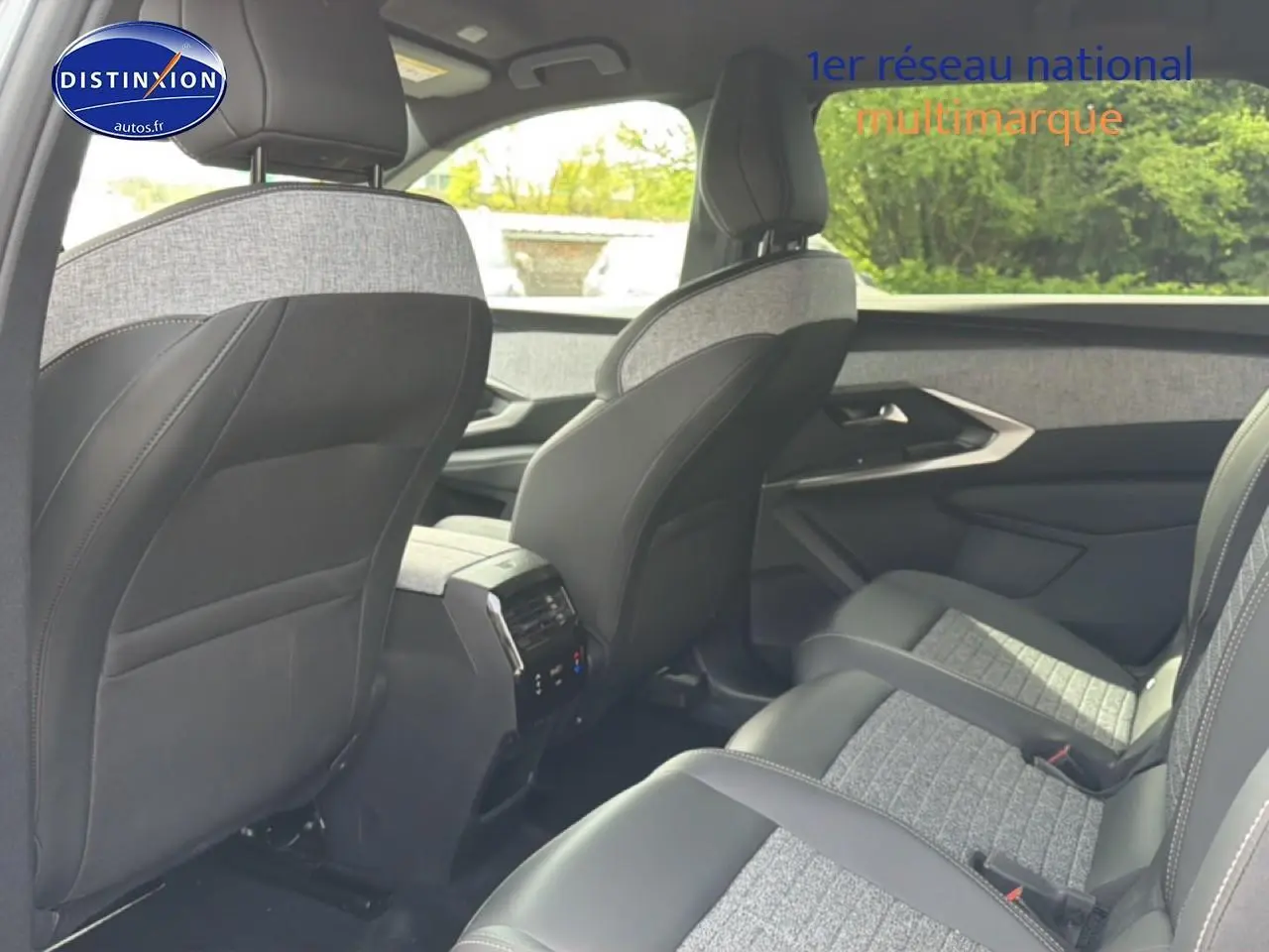 Vue intérieure arrière droite du Peugeot 5008 Hybrid 145 allure gris artense, sièges tissu et cuir bicolore.