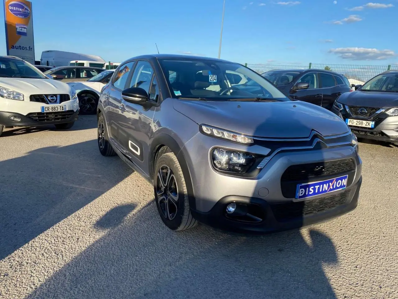 Citroën C3 gris Artense vue 3/4 avant droit, avec signature lumineuse LED et jantes noires distinctives.