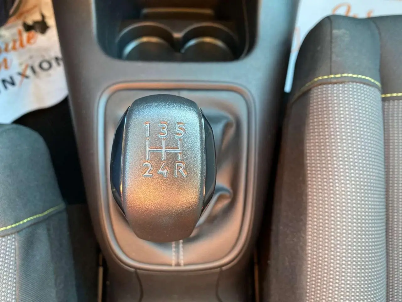 Gros plan sur le levier de vitesses manuel de la Citroën C3 gris Artense, avec coutures contrastées sur la console centrale.