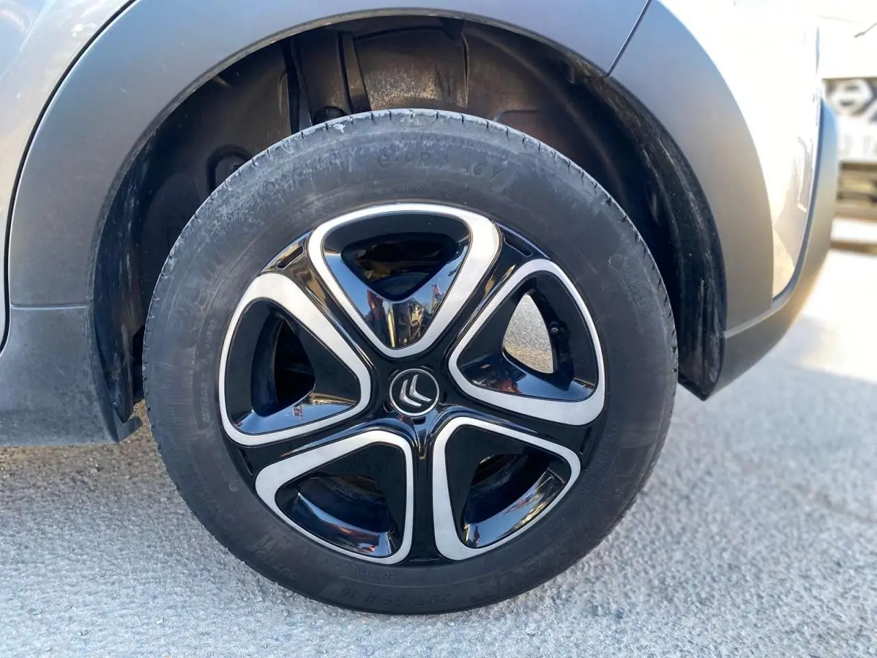 Gros plan sur la roue avant gauche de la Citroën C3 gris Artense avec jante noire et argentée au design moderne.