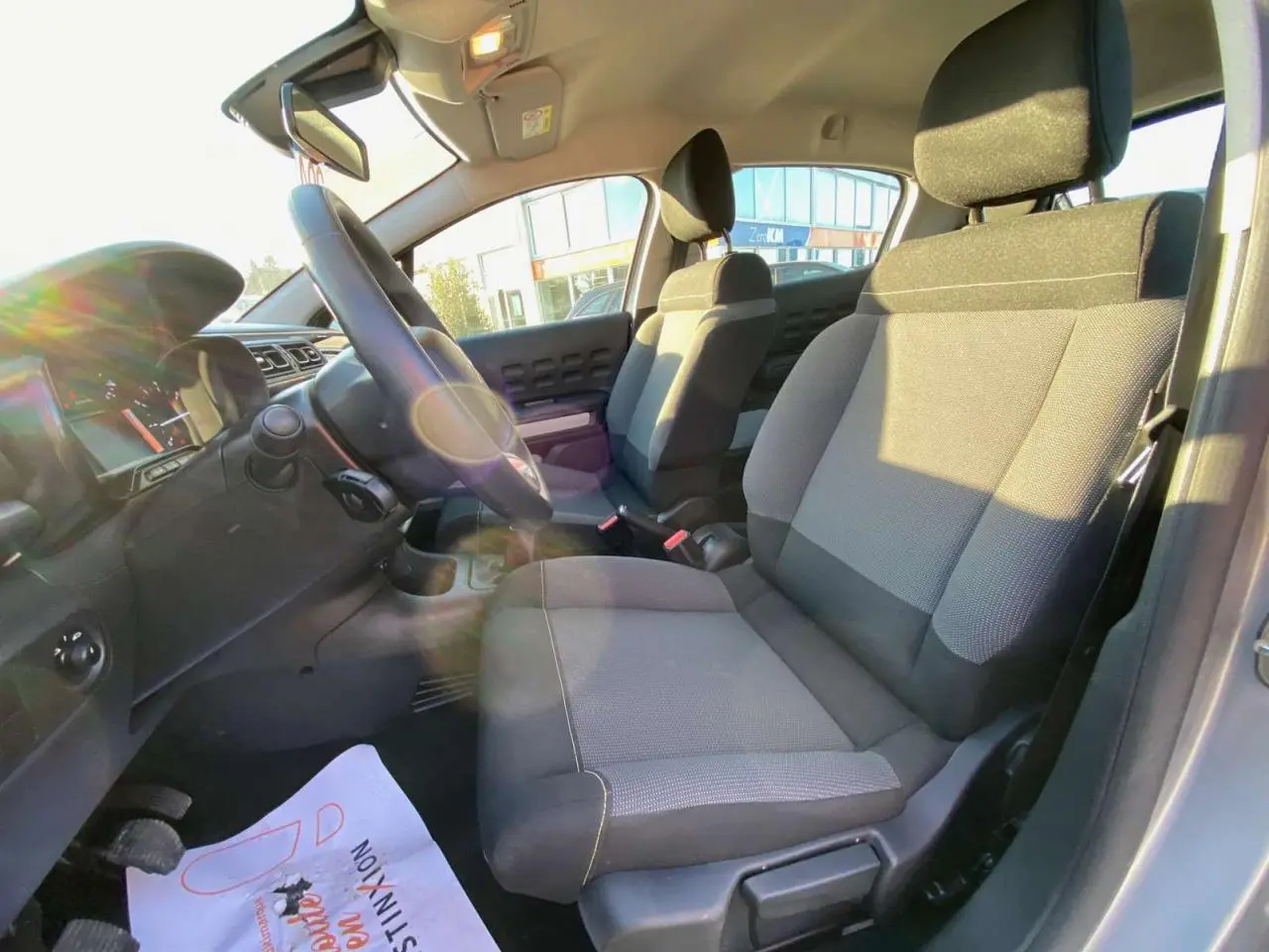 Vue intérieure côté conducteur de la Citroën C3 1.2L Feel Pack 2022 avec sièges gris et volant noir.