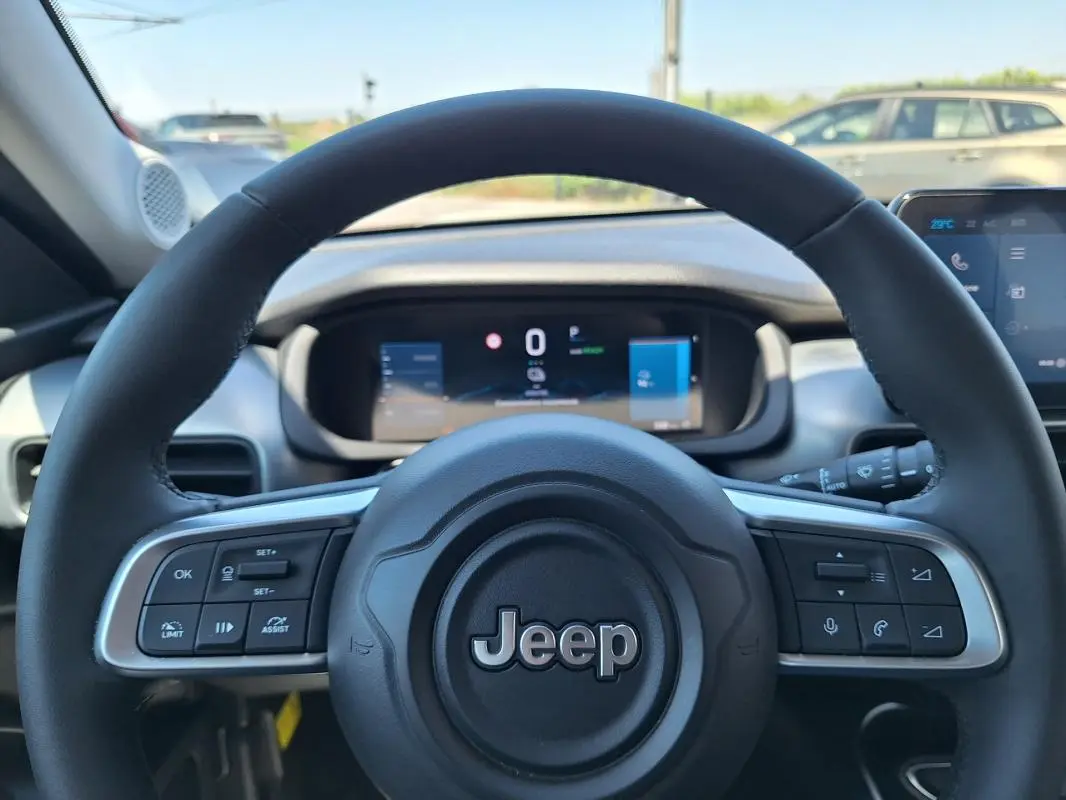 Vue rapprochée du volant noir du Jeep Avenger électrique 2025, avec commandes intégrées et tableau de bord numérique.