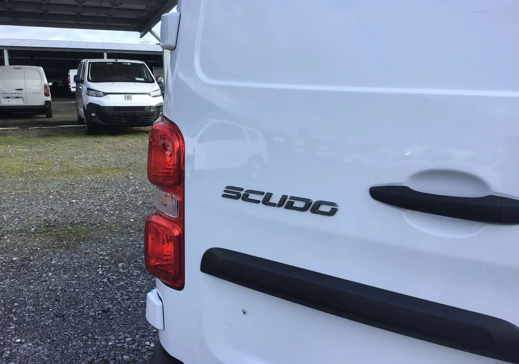 Gros plan sur l'arrière droit blanc du FIAT Scudo Fourgon avec feu rouge et logo Scudo visible.