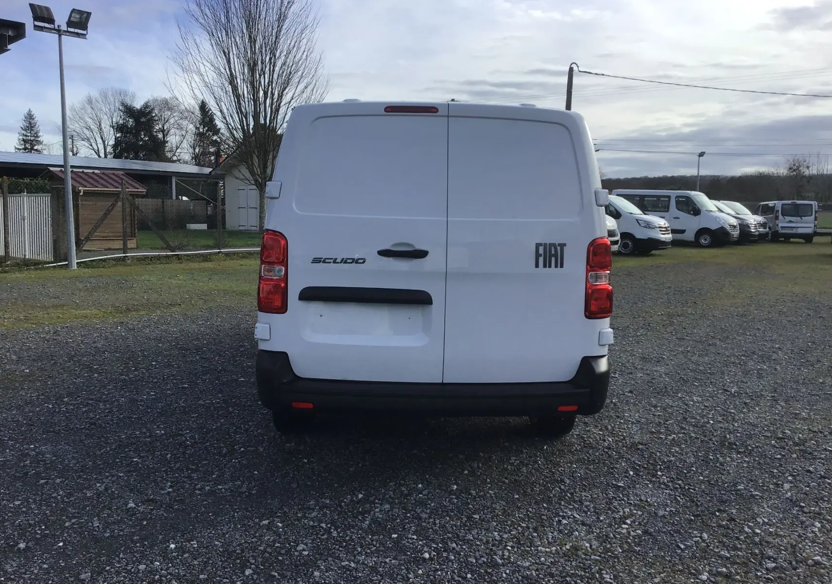 Vue arrière d’un FIAT Scudo Fourgon blanc 2024, avec portes battantes fermées et logo FIAT visible à droite.