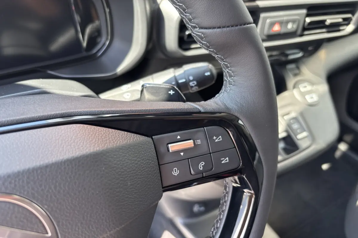 Gros plan sur le volant cuir multifonctions du Citroën Berlingo 2026, avec commandes audio et téléphone intégrées.
