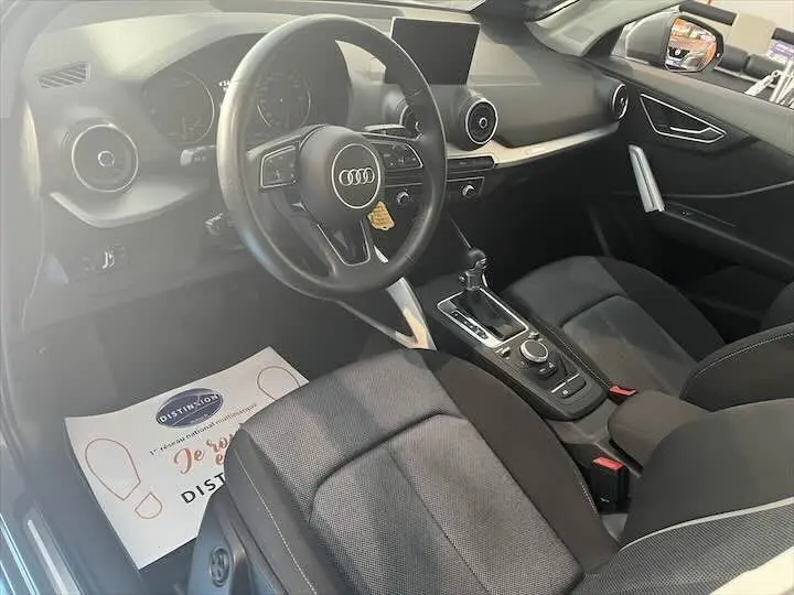 Intérieur de l'Audi Q2 35 TFSI 2020 vu côté conducteur, tableau de bord noir avec volant multifonction et console centrale.