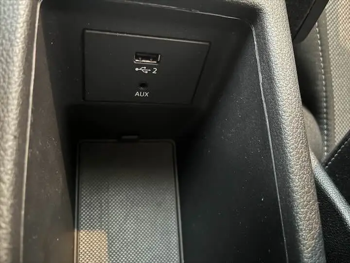 Prise USB et port AUX en gros plan dans la console centrale noire de l'Audi Q2 gris Daytona 2020.