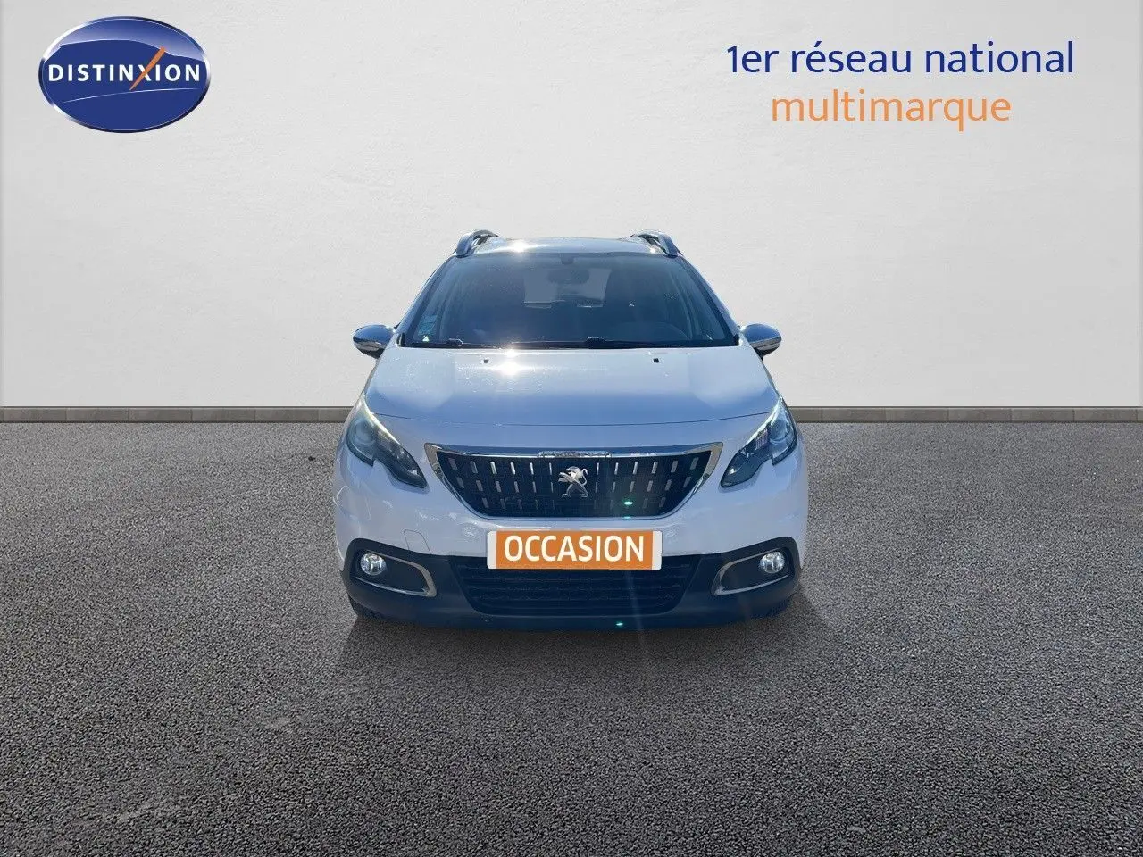 Vue frontale d'un Peugeot 2008 blanc de 2017 avec calandre noire et phares LED allumés.