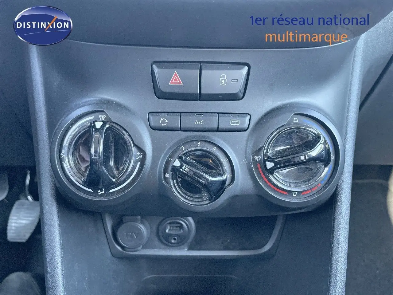 Commandes de climatisation manuelle noires du tableau de bord d'une Peugeot 2008 blanche de 2017 vue en gros plan.