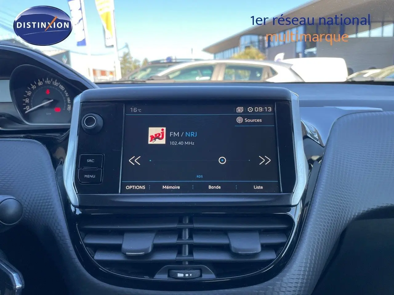 Tableau de bord intérieur du Peugeot 2008 blanc de 2017 avec écran tactile affichant la radio FM NRJ.