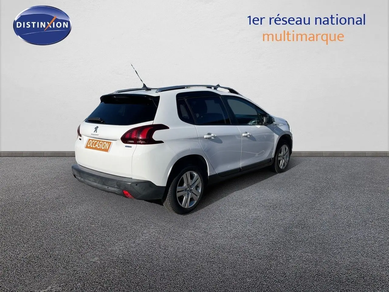 Peugeot 2008 blanc en 3/4 arrière droit, avec toit noir et feux arrière LED, stationné devant un mur blanc.