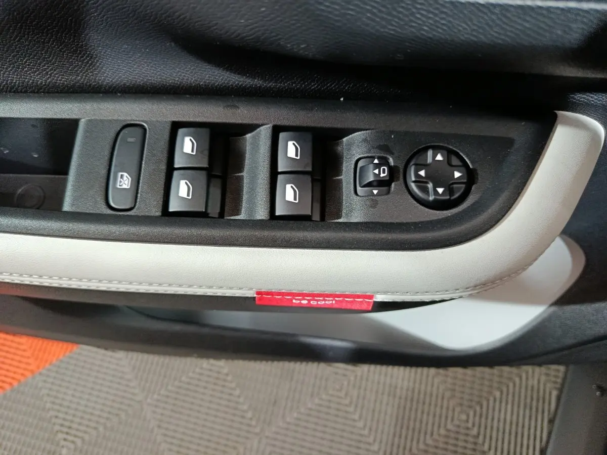 Gros plan sur les commandes de lève-vitres et réglage des rétroviseurs côté conducteur de la Citroën C3 hybride 2025.