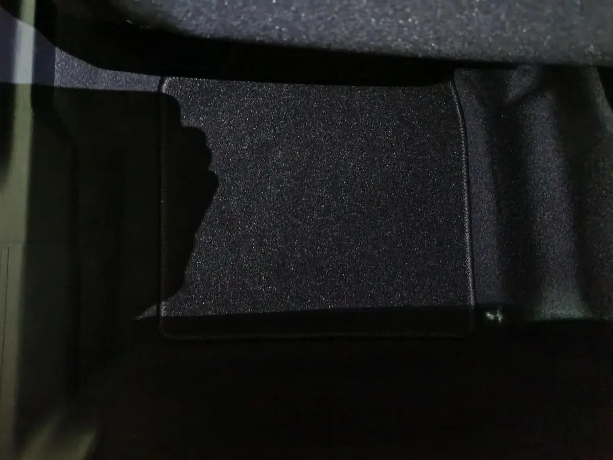 Détail du tapis de sol noir à l'avant gauche de la Citroën C3 hybride 2025, vue intérieure rapprochée.