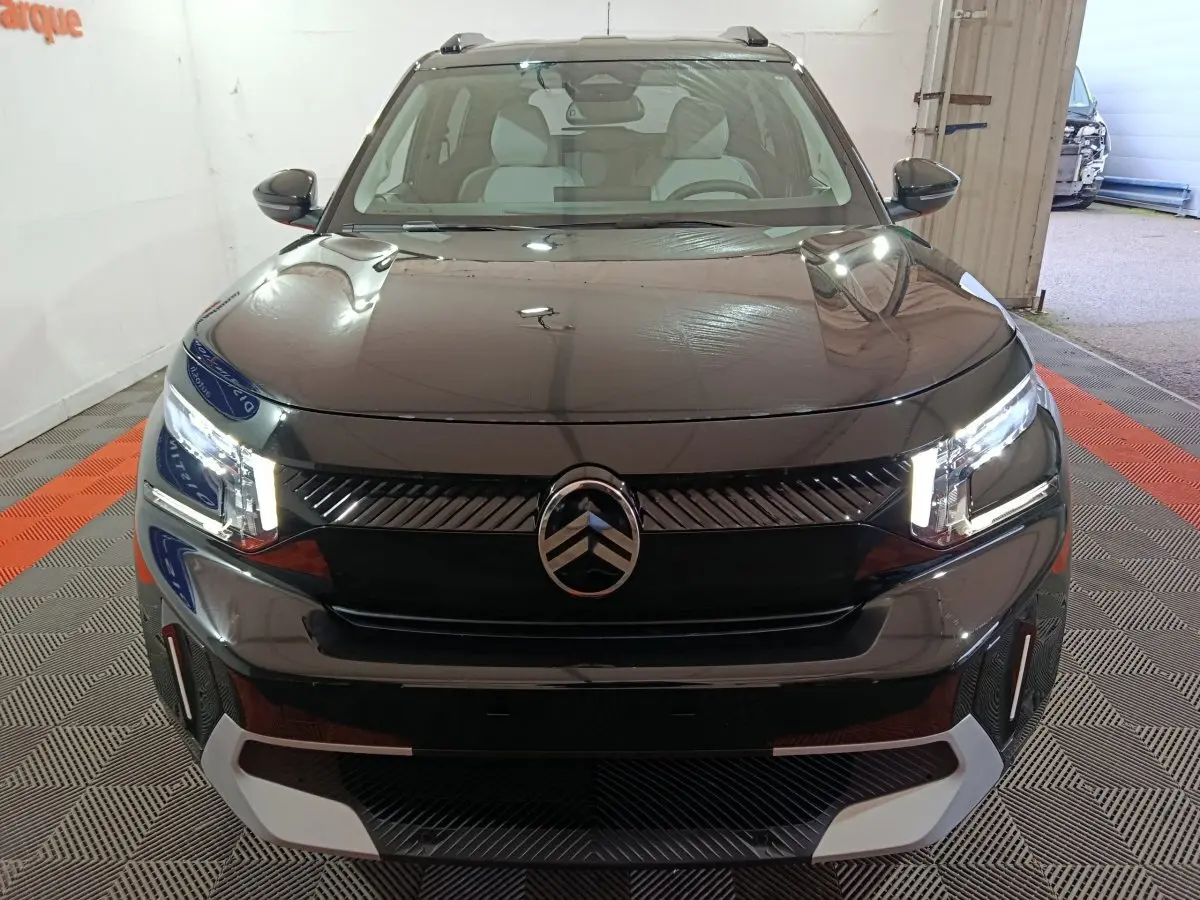 Vue frontale d'une Citroën C3 hybride noire 2025 avec phares LED et calandre noire brillante.