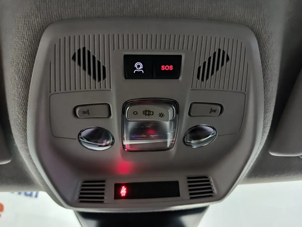 Vue en gros plan du plafonnier gris avec bouton SOS et commandes d'éclairage dans une Citroën C3 noire hybride 2025.