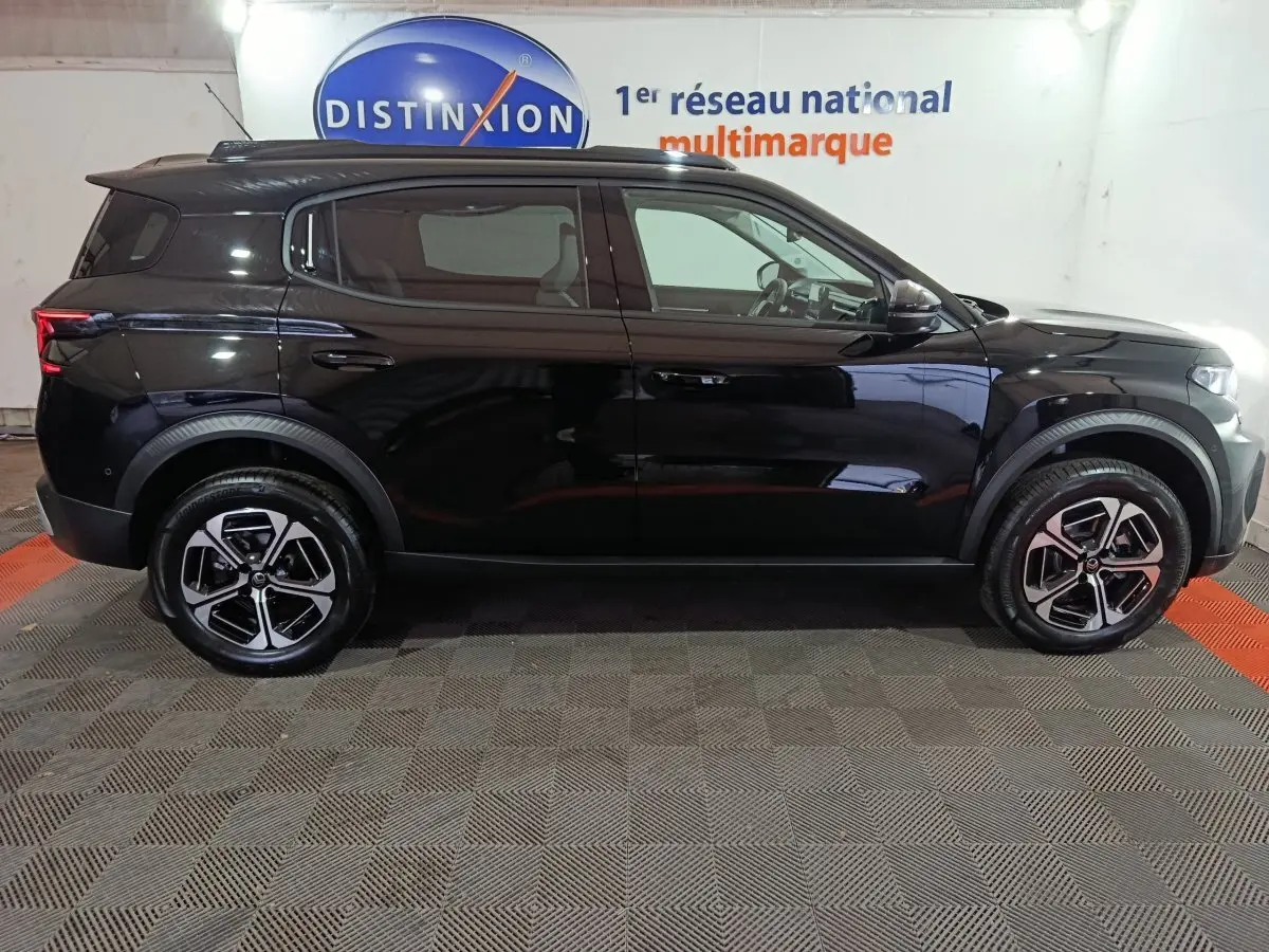 Vue de profil côté gauche d'un SUV Citroën noir, avec jantes alliage et poignées de porte intégrées.