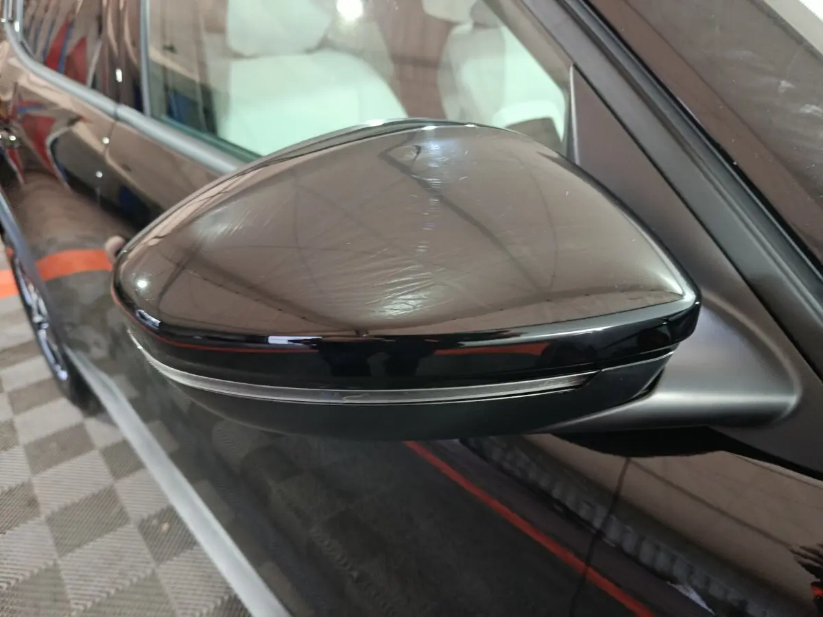 Gros plan sur le rétroviseur côté gauche noir brillant de la Citroën C3 hybride 2025 avec clignotant intégré.