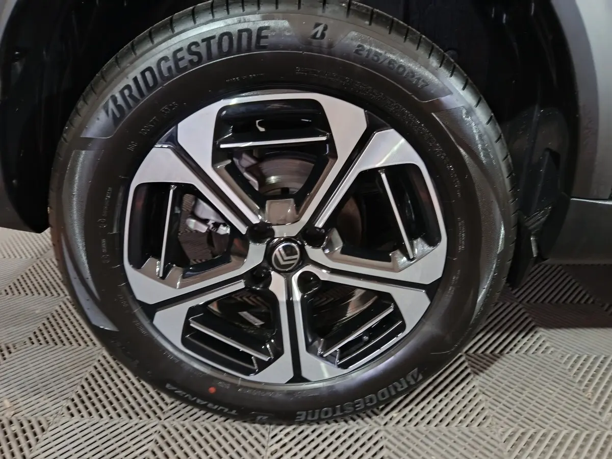 Gros plan sur la jante alliage noire et argentée de la Citroën C3 Hybride 136 e-DSC6 MAX, pneu Bridgestone visible.