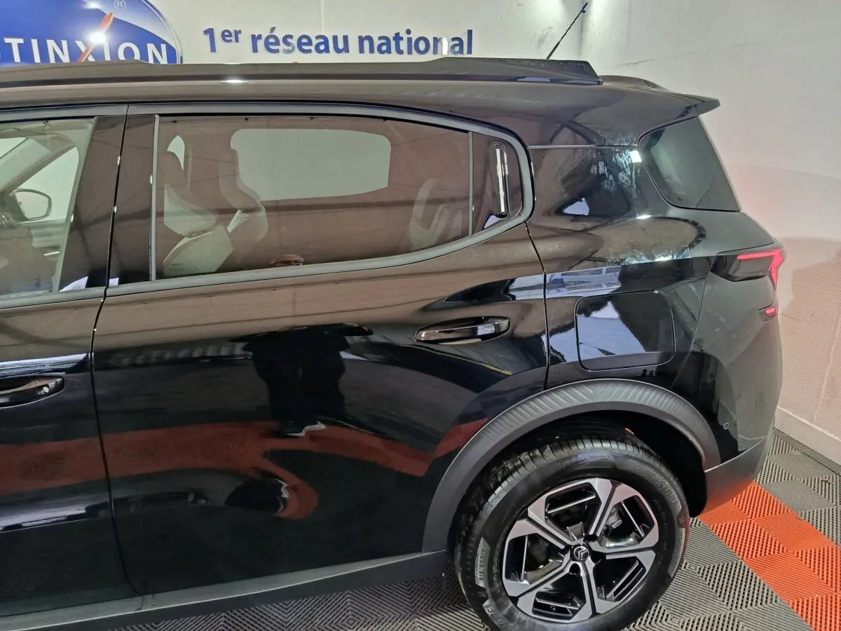 Vue côté droit arrière d'une Citroën C3 hybride noire avec jantes alliage et feux arrière LED distinctifs.